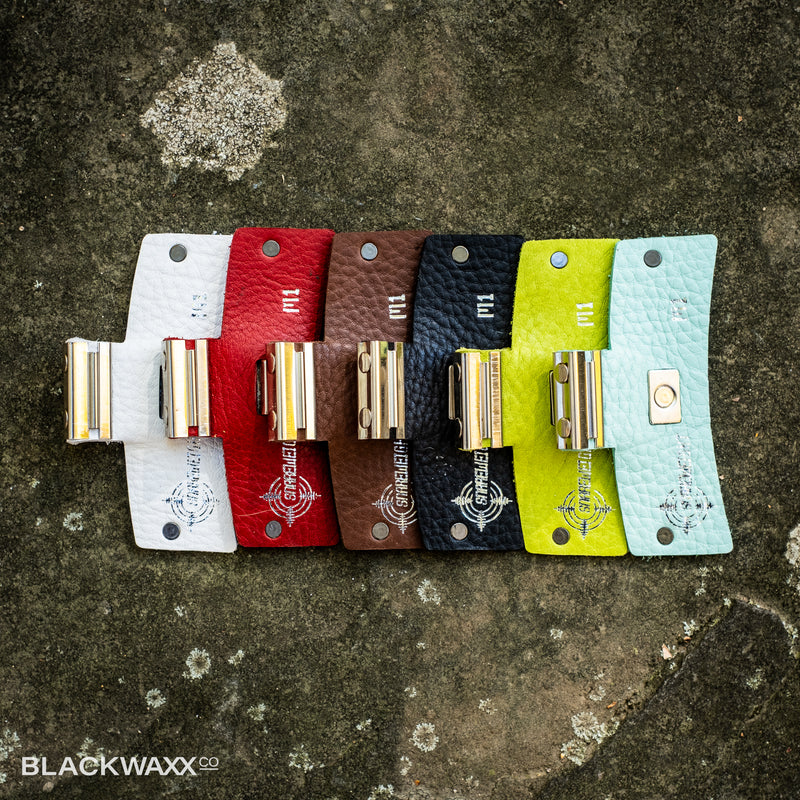 Snareweight M1 drum dampeners in all six colours: white, red, brown, black, wasabi green and sea foam green, lined up side by side