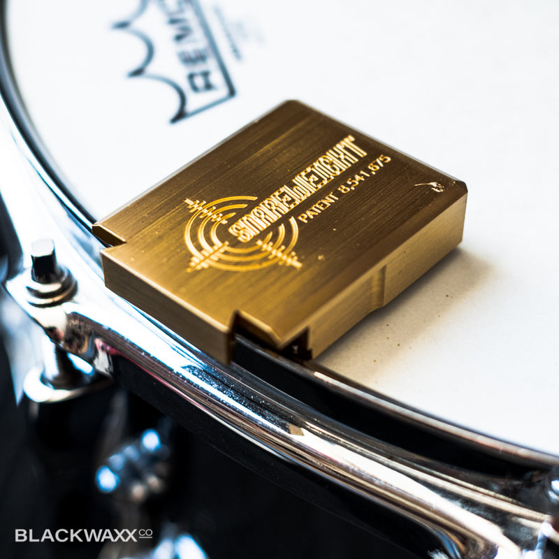 Snareweight #5 solid brass snare drum dampener on a snare drum hoop